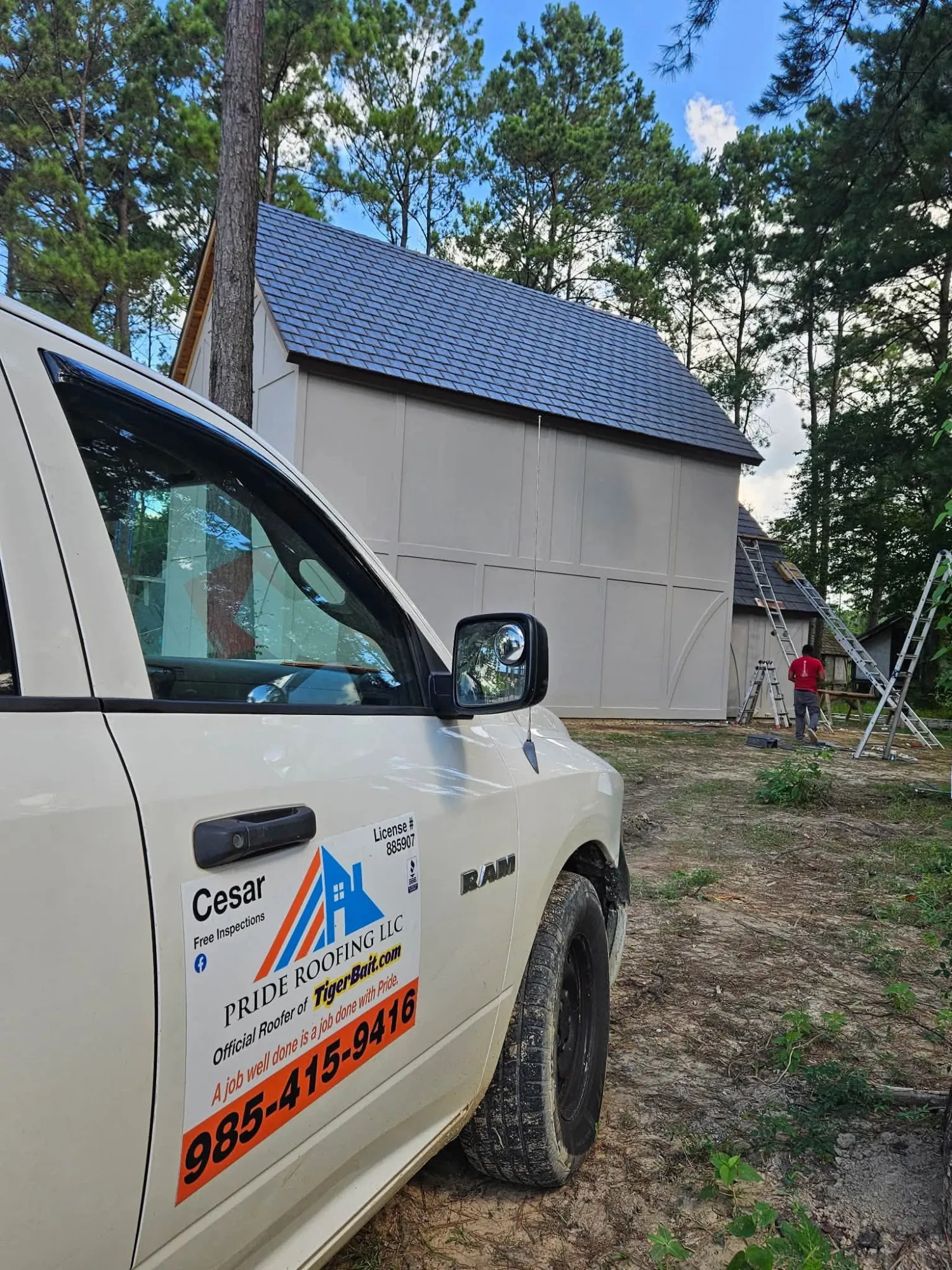 Pride Roofing work truck offering free inspections, parked at a job site