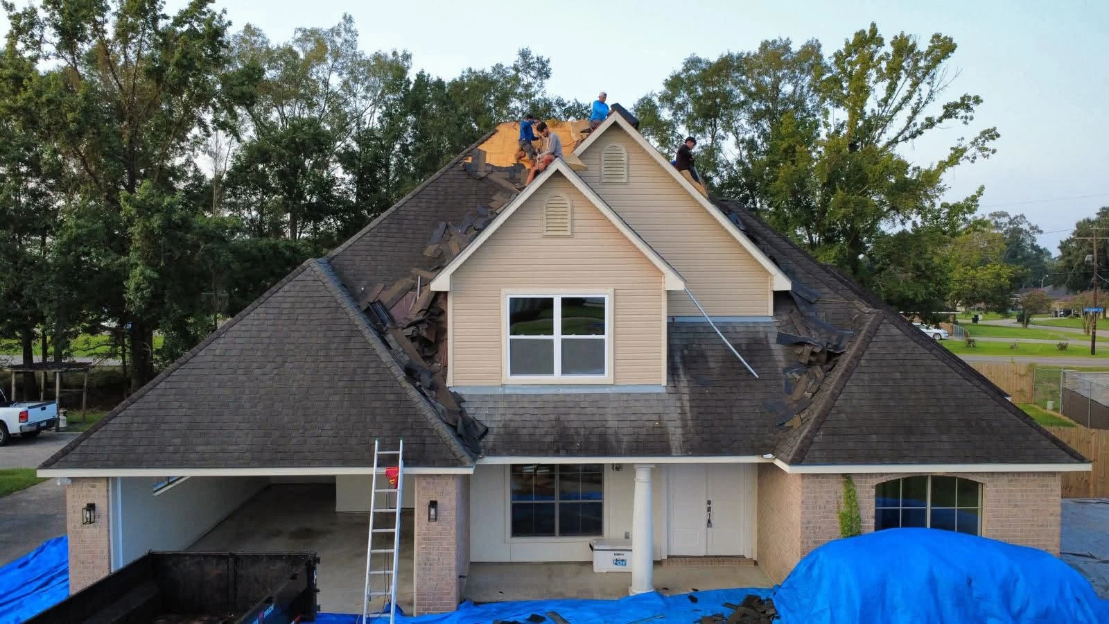 Drone view of the crew tearing off a two-story hip roof