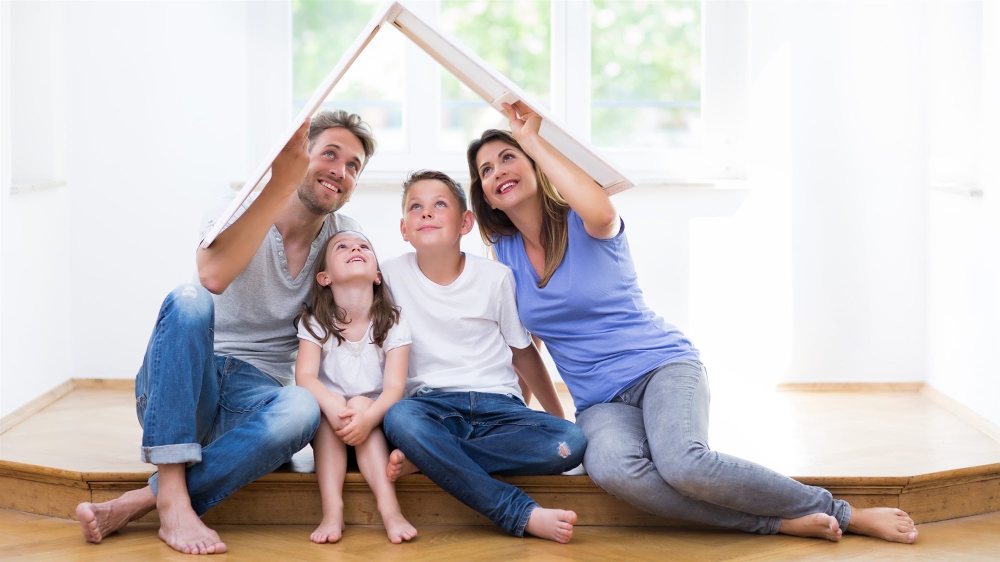 Family sitting together under a model roof